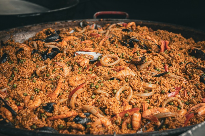 A large, authentic seafood paella (paella de marisco) in a traditional pan, topped with prawns and mussels.