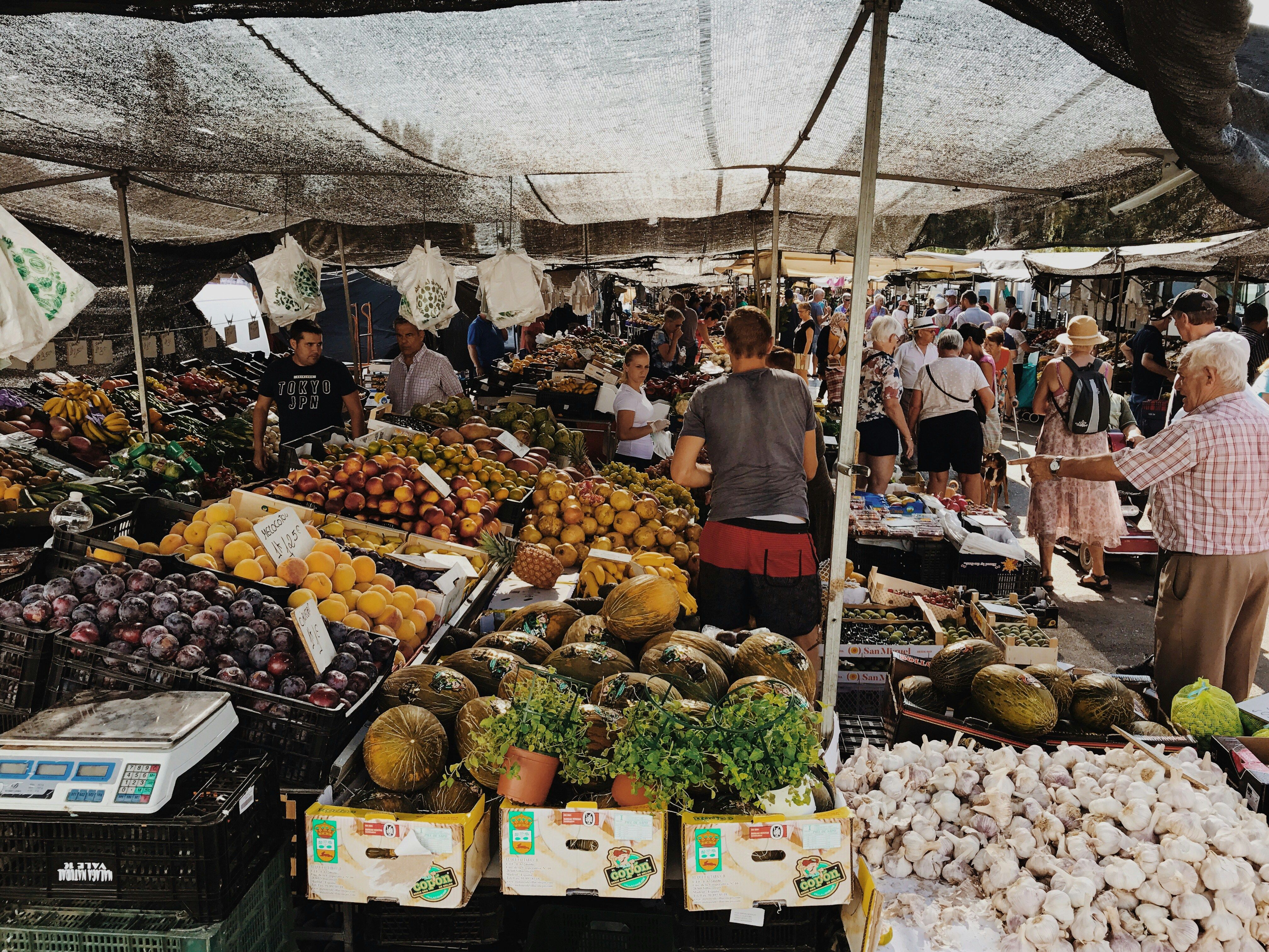 A colorful market stall at a mercado municipal in Spain, showcasing fresh produce and the benefits of supporting local businesses.